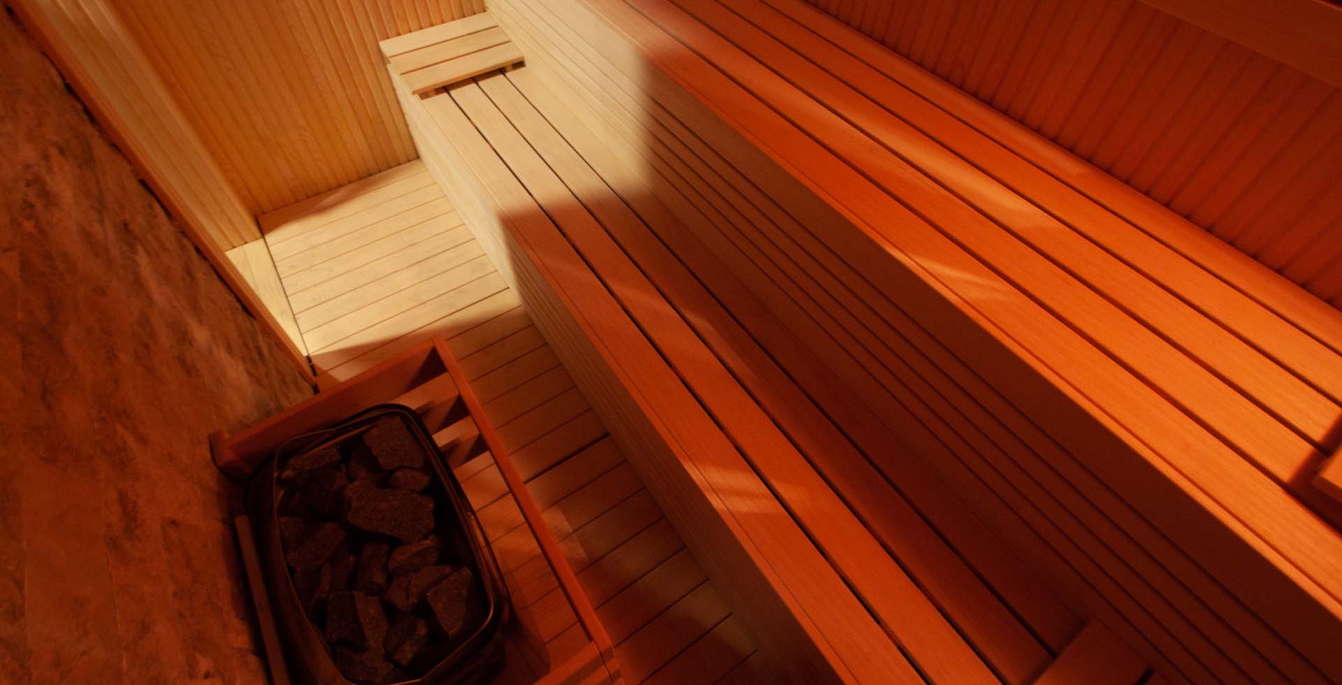Interior of a cozy sauna in Amsterdam, with wooden benches, ambient lighting, and a tranquil atmosphere for relaxation and rejuvenation.
